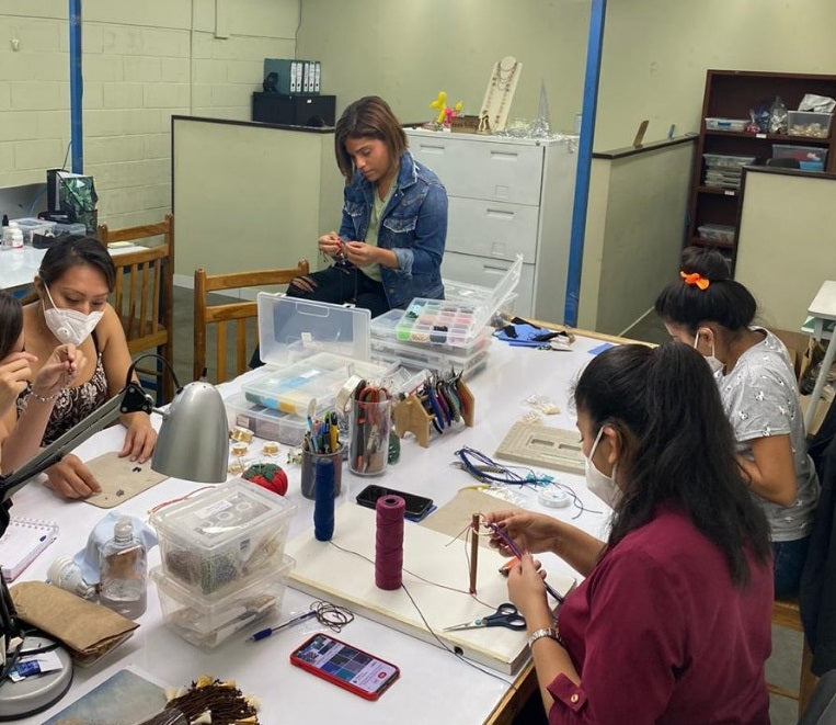 Woman working in a workshop elaborating handmade earrings 