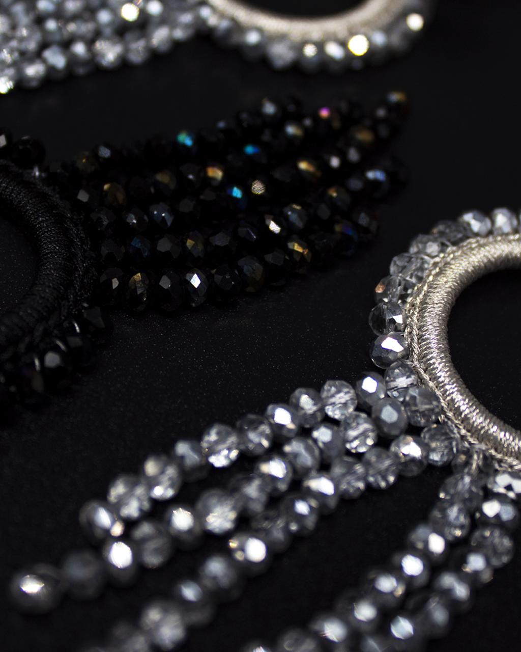 Close-up of decorative headbands with crystal embellishments on a black background
