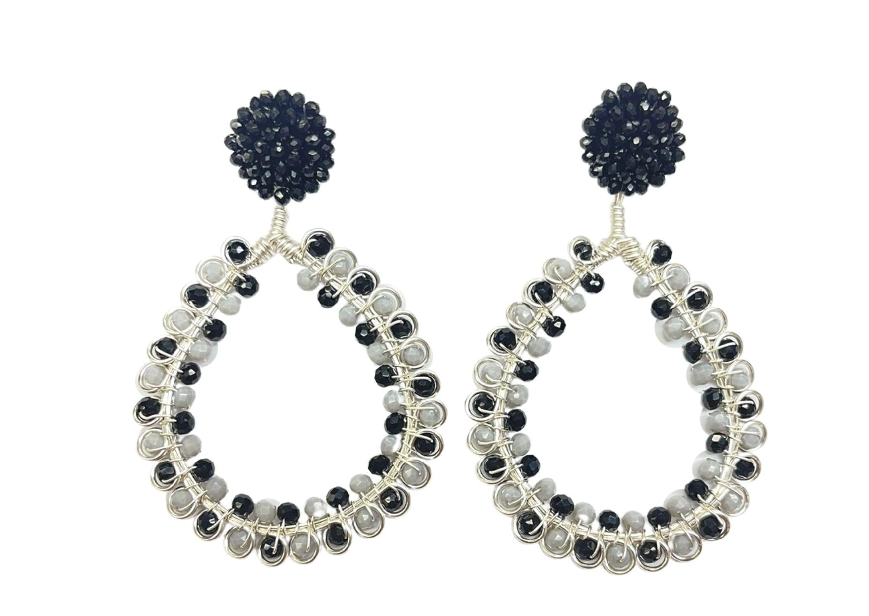 Pair of hoop earrings with black and white gemstones on a white background