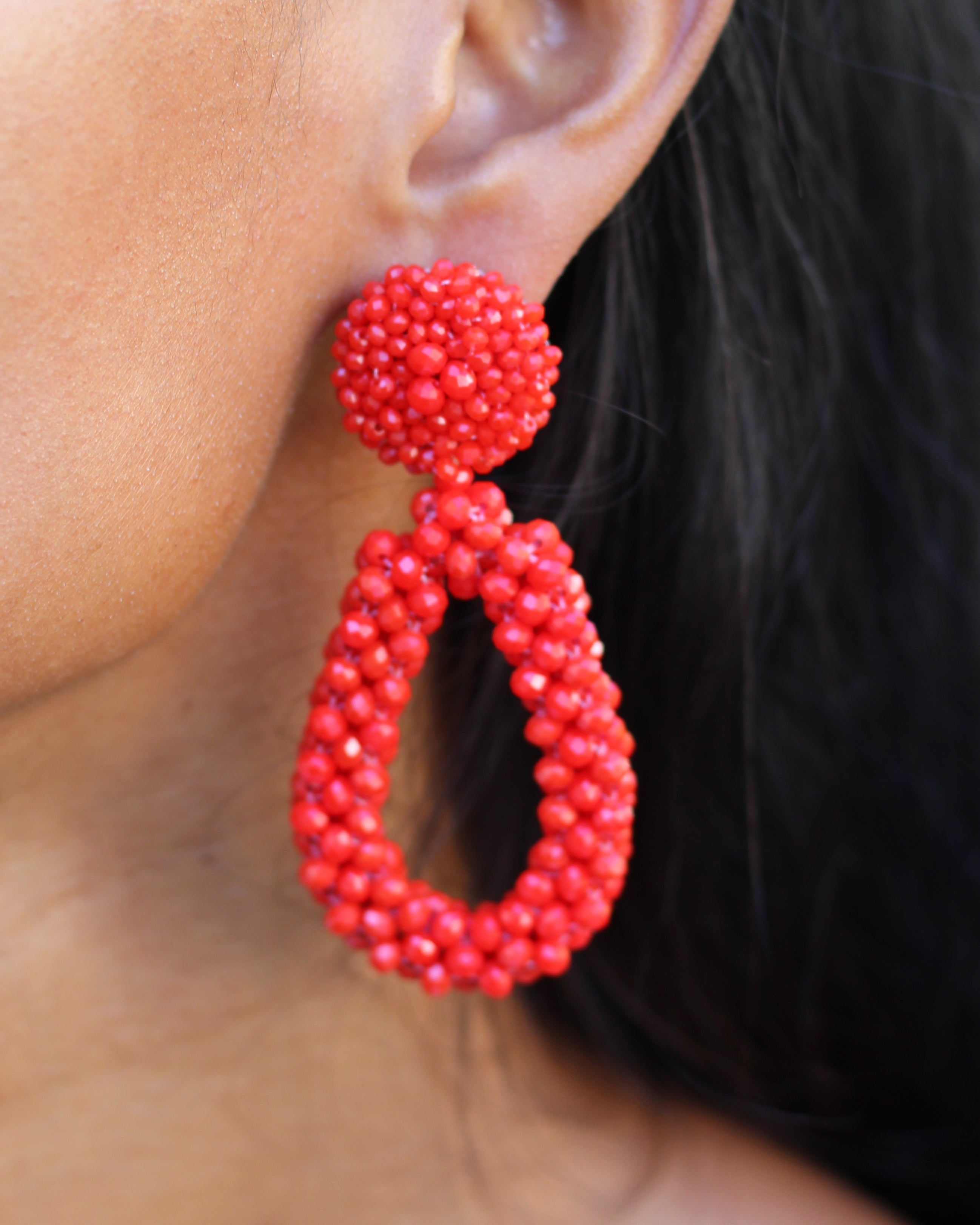 Pair of red beaded earrings on a white background